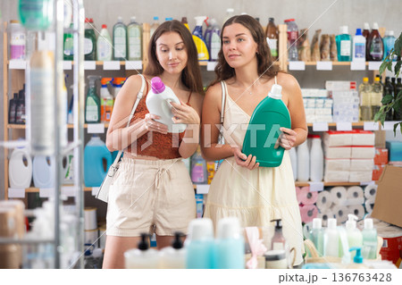 Women friends choose detergent in store Women friends choose detergent in store 136763428