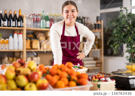 Smiling saleswoman behind the store counter Smiling saleswoman behind the store counter 136763436