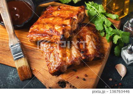 Spicy hot grilled spare ribs from a summer BBQ served with a hot chili pepper and fresh tomatoes 136763446