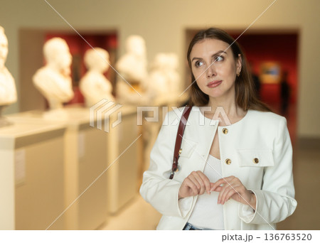Thoughtful young woman in a sculpture museum Thoughtful young woman in a sculpture museum 136763520