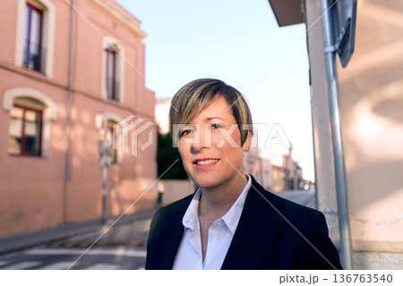 Portrait of businesswoman in urban street 136763540