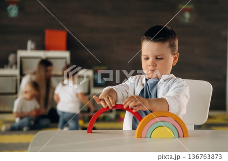 Rainbow toy game. Group of children are in the kindergarten Rainbow toy game. Group of children are in the kindergarten 136763873