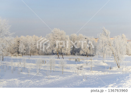 A winter scene with trees covered in hoarfrost under a clear blue sky. Season 136763960