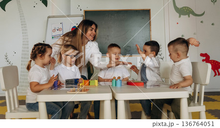 Colorful toys, educational game. Children in kindergarten with their teacher 136764051