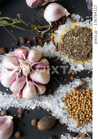 seasonings background with salt, Spices and garlic served at black. natural meal additives. healthy food concept. flat lay macro shot seasonings background with salt, Spices and garlic served at black. natural meal additives. healthy food concept. flat lay macro shot 136764117