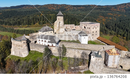 Aerial view of a well-preserved medieval stone castle on a hilltop. 136764208