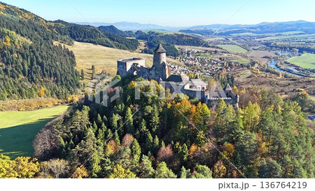Aerial view of a well-preserved medieval stone castle on a hilltop. 136764219
