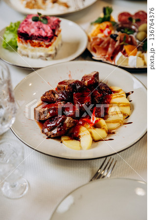 Gourmet meat dish with sauce and potatoes served at elegant restaurant dinner 136764376