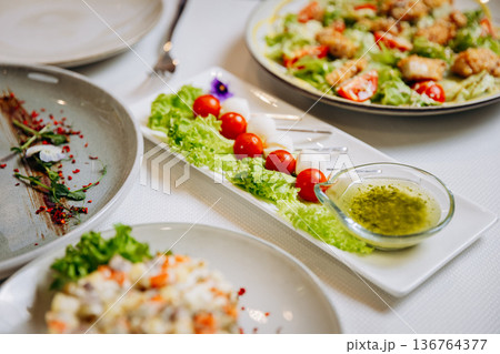 Fresh vegetable appetizer with cherry tomatoes, lettuce and green herb dressing Fresh vegetable appetizer with cherry tomatoes, lettuce and green herb dressing 136764377
