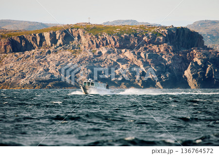 the coast of the Barents Sea, pleasure boats in the sea, the rocky shore with colourful arctic carpet of moss, yagel, Tundra at autumn the coast of the Barents Sea, pleasure boats in the sea, the rocky shore with colourful arctic carpet of moss, yagel, Tundra at autumn 136764572