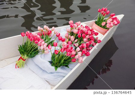 Bouquet of pink tulips in a boat on the water 136764645