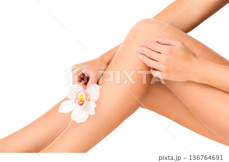 Beautiful female legs with orchid flower, isolated, close-up Beautiful female legs with orchid flower, isolated, close-up 136764691