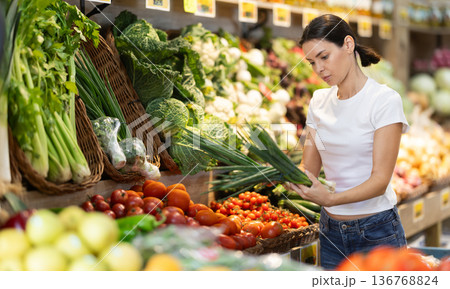 Woman choosing a bunch of green onions 136768824