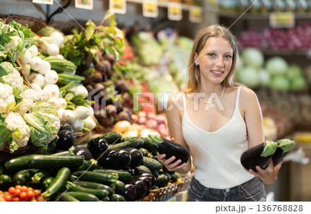 Young woman choosing eggplant Young woman choosing eggplant 136768828