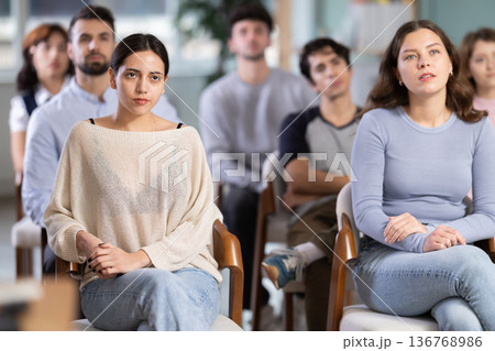 Group of young students listening during seminar in a modern classroom Group of young students listening during seminar in a modern classroom 136768986