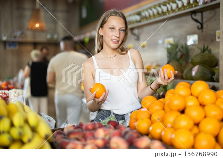 Woman choosing oranges in a supermarket 136768990