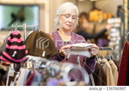 Mature woman choosing high quality hats in the store Mature woman choosing high quality hats in the store 136768997