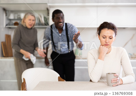 Woman not talking after disagreement with husband and mother standing behind Woman not talking after disagreement with husband and mother standing behind 136769308