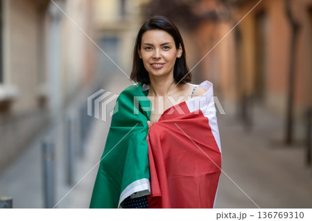 Girl wrapped in Italian flag on city street Girl wrapped in Italian flag on city street 136769310