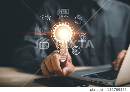 Learn how skills in technology, digits, and online e-learning are developing as close-up shows someone using a laptop to learn new creative ideas for teaching graduation and knowledge using internet 136769383