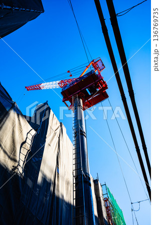 市街地のマンション建設とタワークレーンと電線 f-2 高彩度コントラスト 市街地のマンション建設とタワークレーンと電線 f-2 高彩度コントラスト 136769735