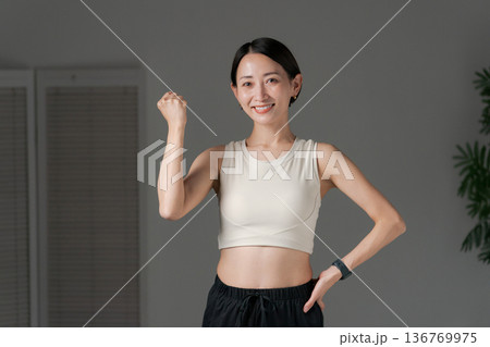 ガッツポーズをするトレーニングウェアの女性 ガッツポーズをするトレーニングウェアの女性 136769975