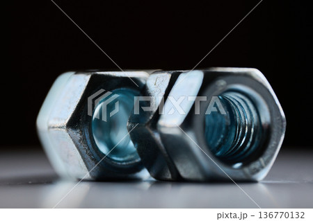 Detailed close up of chrome plated internal thread fasteners with shallow depth of field 136770132