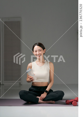 ヨガウェアに座るスポーツウェアの女性 ヨガウェアに座るスポーツウェアの女性 136770320