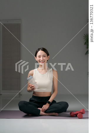 ヨガウェアに座るスポーツウェアの女性 136770321