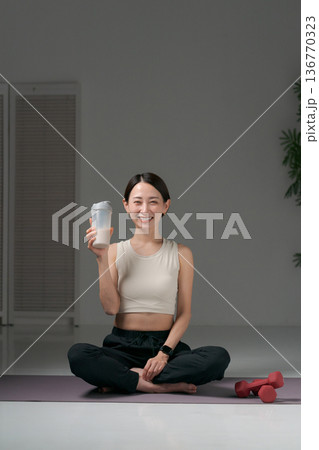 ヨガウェアに座るスポーツウェアの女性 136770323