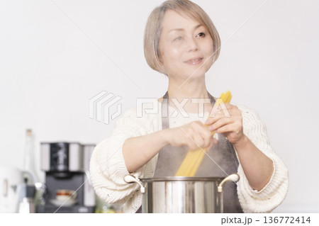 キッチンでパスタを茹でるシニア女性 136772414