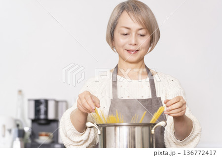 キッチンでパスタを茹でるシニア女性 136772417