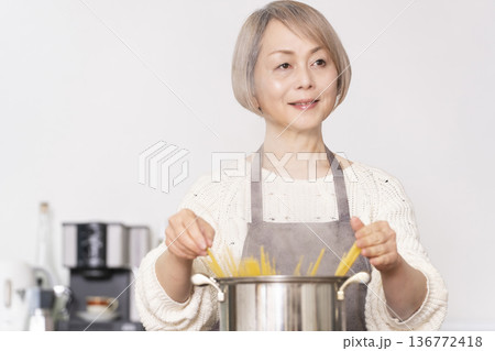 キッチンでパスタを茹でるシニア女性 136772418