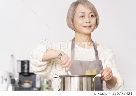 キッチンでパスタを茹でるシニア女性 136772421