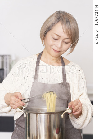 キッチンでパスタを茹でるシニア女性 136772444