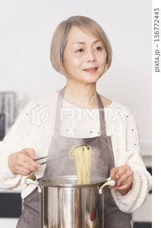 キッチンでパスタを茹でるシニア女性 136772445
