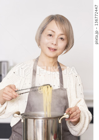 キッチンでパスタを茹でるシニア女性 136772447