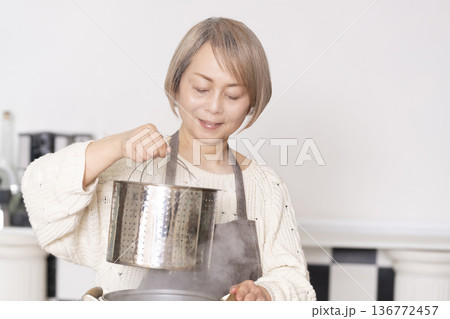キッチンでパスタを茹でるシニア女性 キッチンでパスタを茹でるシニア女性 136772457