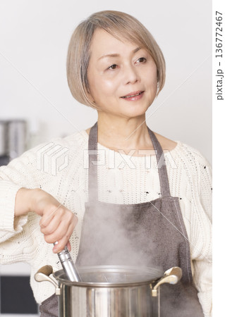 キッチンでパスタを茹でるシニア女性 キッチンでパスタを茹でるシニア女性 136772467