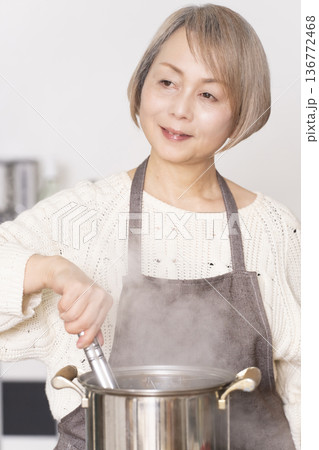 キッチンでパスタを茹でるシニア女性 キッチンでパスタを茹でるシニア女性 136772468