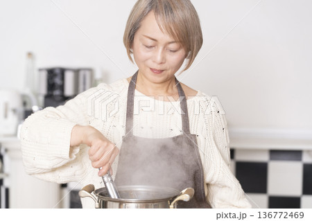 キッチンでパスタを茹でるシニア女性 キッチンでパスタを茹でるシニア女性 136772469