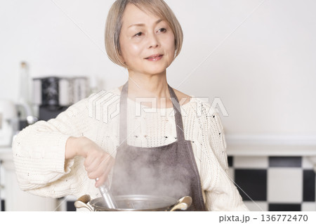 キッチンでパスタを茹でるシニア女性 キッチンでパスタを茹でるシニア女性 136772470