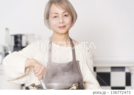 キッチンでパスタを茹でるシニア女性 キッチンでパスタを茹でるシニア女性 136772473