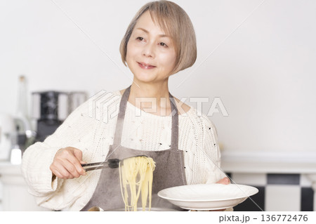 キッチンでパスタを茹でるシニア女性 136772476