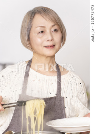 キッチンでパスタを茹でるシニア女性 136772478