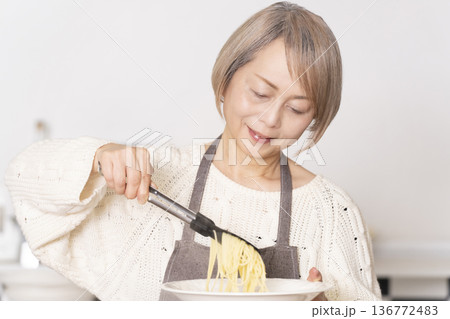 キッチンでパスタを茹でるシニア女性 136772483