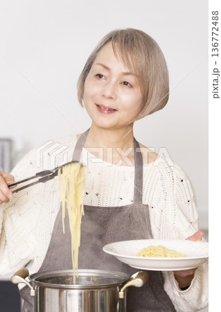 キッチンでパスタを茹でるシニア女性 136772488