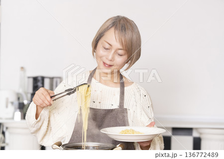 キッチンでパスタを茹でるシニア女性 136772489