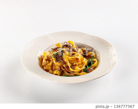 Gourmet fettuccine pasta with beef ragu and spinach, served in an ornate bowl on a white background Gourmet fettuccine pasta with beef ragu and spinach, served in an ornate bowl on a white background 136777367