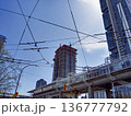 Urban view with power lines crossing blue sky background 136777792